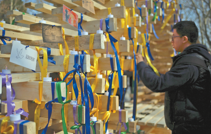 ▲东南大学学生为搭起的木架系上寄望和平的彩色丝带。