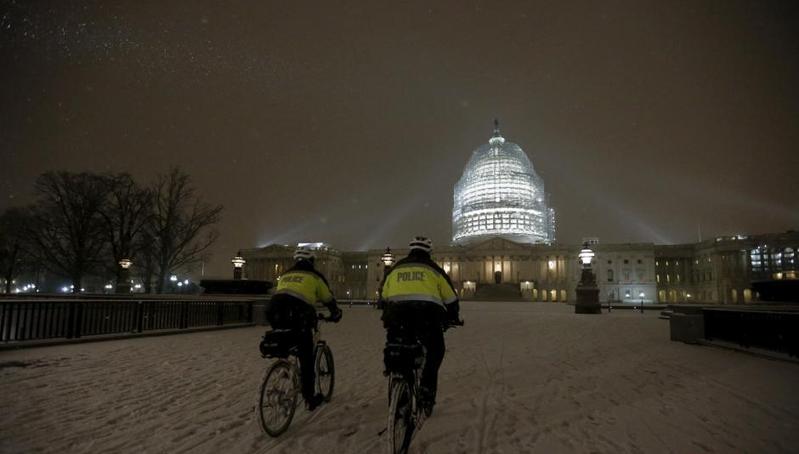 华盛顿21日迎来降雪，国会山的安保人员在雪地里骑车巡逻。（中新网/图）