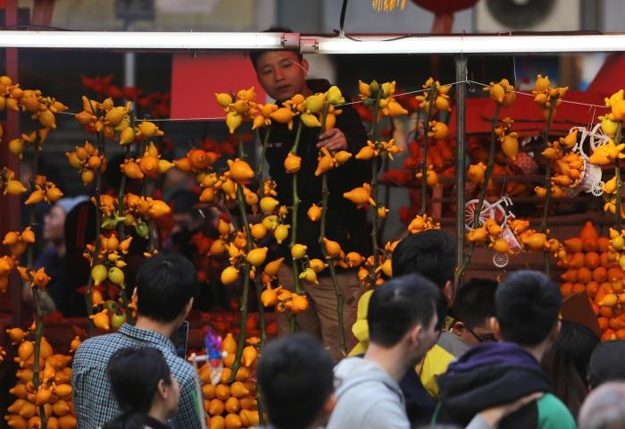 年二十八艳阳高照，不少市民全家总动员逛花街。西湖花市也人山人海。张由琼摄