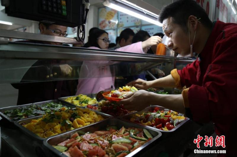 3月23日,武昌工学院食堂内,学生排队挑选水果菜.