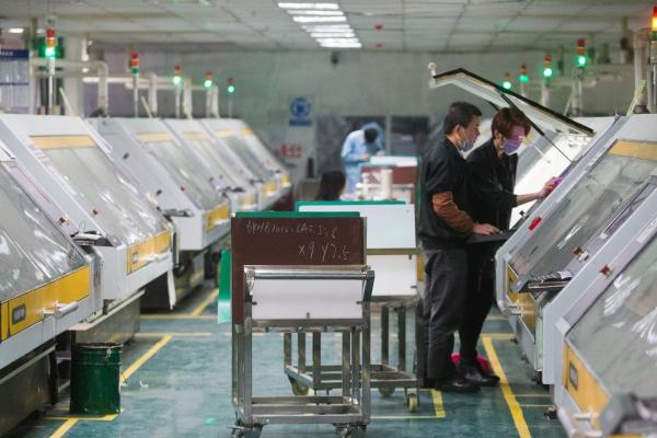 东莞五株科技的手机HDI电路板生产车间，操作机器的技工在调试机器。（南方日报记者 孙俊杰 摄）