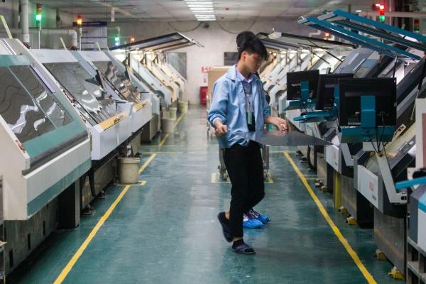 东莞五株科技的手机HDI电路板生产车间，操作机器的技工给机器加料。（南方日报记者 孙俊杰 摄）