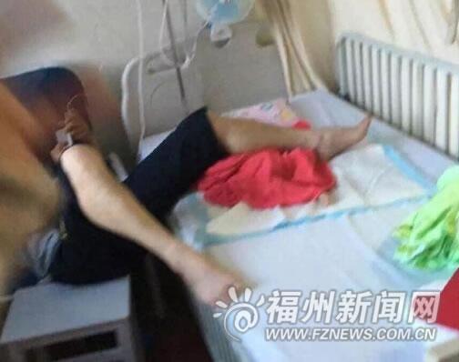 男子腿下面这团被单里裹的就是这名患病女婴。