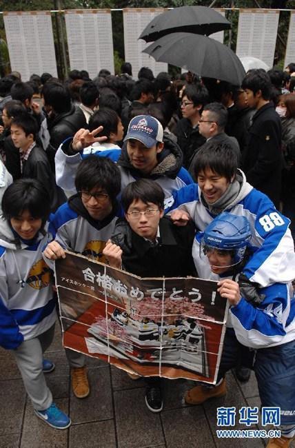 2012年3月10日，在日本东京大学校园，日本东京大学在校园内张榜公布考上该校的新生考号，一名榜上有名的考生留影。关贤一郎 摄