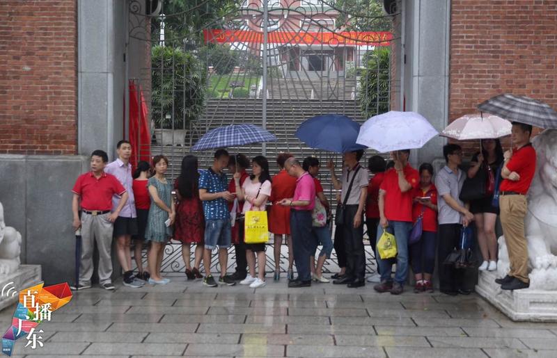 执信中学考点外，家长们在雨中等待考试结束。南方+记者 王良珏 摄