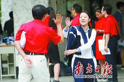 在深圳实验学校，高考首日最后一场考试结束，一名考生与老师击掌相庆。朱洪波 摄