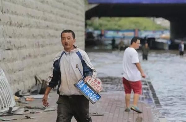 暴雨中捞车牌俨然成了一门生意。（资料图）