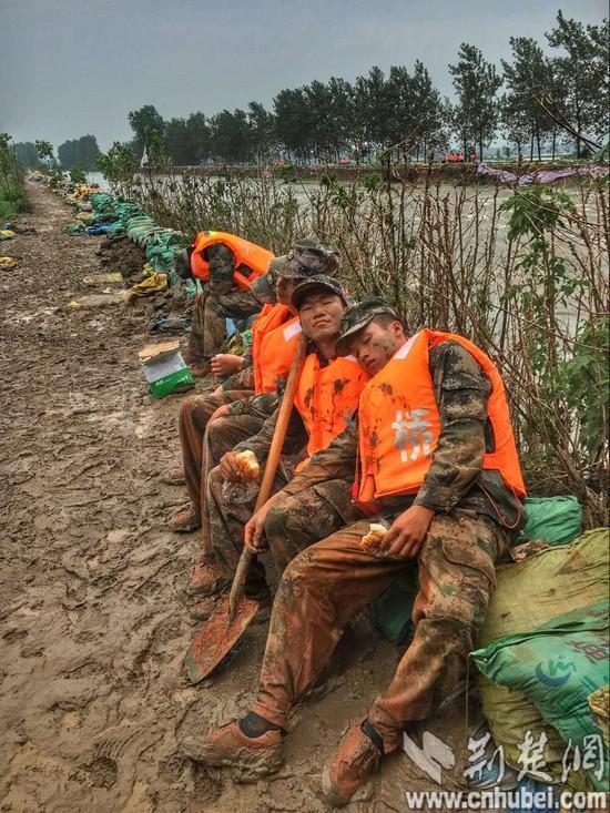 已经连续奋战25小时的官兵战士们刚啃了一口面包,就忘了饿,累得"瘫倒"