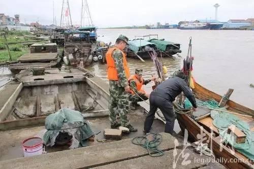 ↑为应对“尼伯特”来袭，江苏公安边防总队大丰边防大队全警动员，提前做好辖区安全防范工作。图为官兵为渔船民加固缆绳。