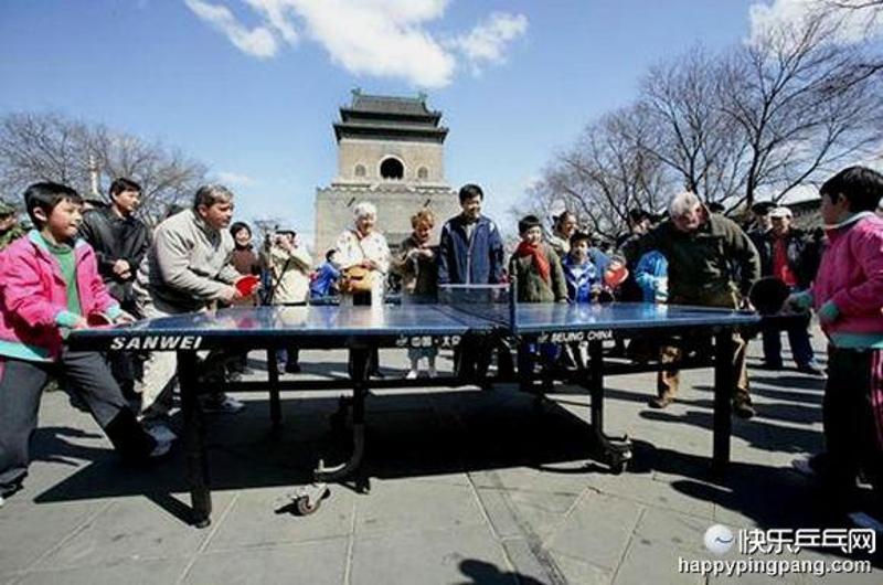 2007年4月2日，在北京安定门街道钟鼓楼文化广场，数百名来自社区的乒乓球爱好者摆开擂台，拉开迎奥运“和谐社区杯”乒乓球比赛的序幕。比赛吸引了几位外国游客挥拍上阵。（张传东摄）