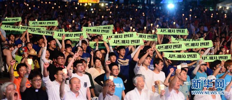 8月14日晚，在韩国首尔，韩国民众在集会上高举标语反对韩国部署“萨德”系统。当日，近5000名韩国民众在首尔举行大规模抗议集会，反对韩国政府决定部署“萨德”系统。（新华社/纽西斯通讯社）