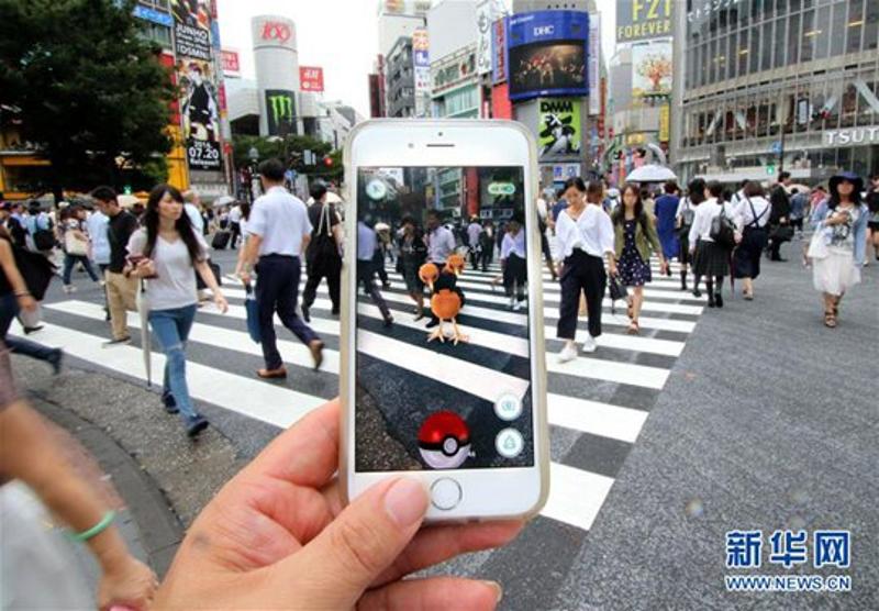 在日本东京街头，一名玩家正在玩名为《Pokemon GO》手机游戏。图片来自新华网