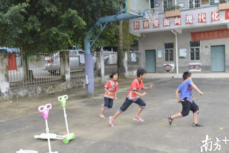 放学等班车空隙，来家燕、来钰莹与附近的小朋友在操场玩游戏。