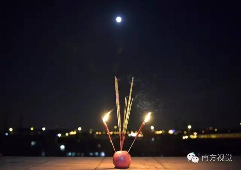 △赏月前，余姨把水果、月饼摆在桌上拜月光。