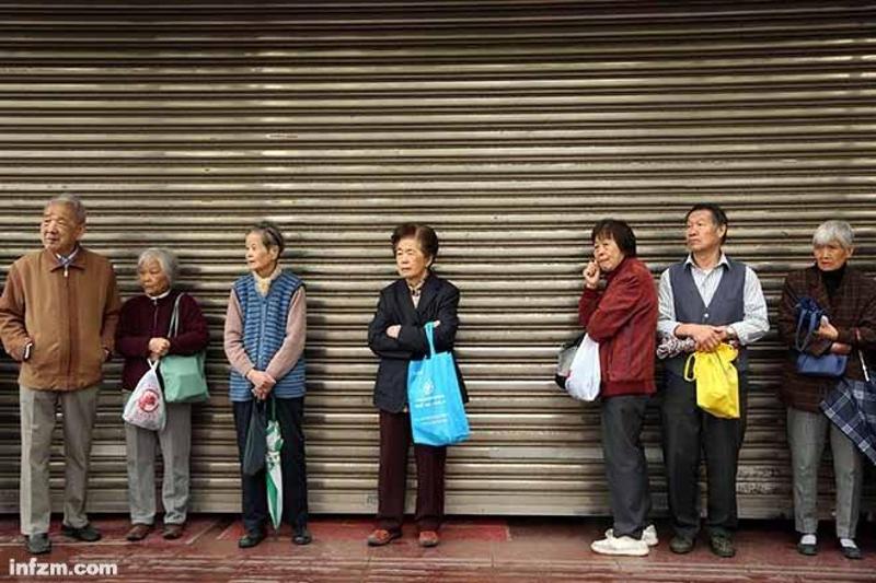 2016年5月10日一大早，上海，市民冒雨到各银行网点门口排队购买2016年第二批凭证式国债。今年以来，无论是凭证式国债还是电子式国债，均受到投资者青睐。（东方IC/图）