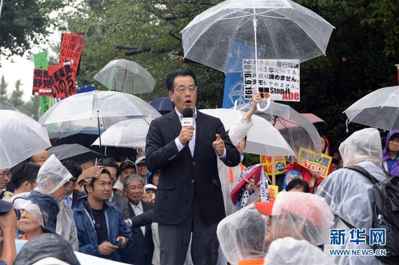 9月19日，在日本东京，日本民进党前党首冈田克也（中）在活动上痛斥新安保法。当日，安倍政府凭借在国会中的议席优势强行通过新安保法迎来一周年。当天下午，约2．3万日本民众在东京举行抗议集会，呼吁废除新安保法。（新华社记者 马平 摄）