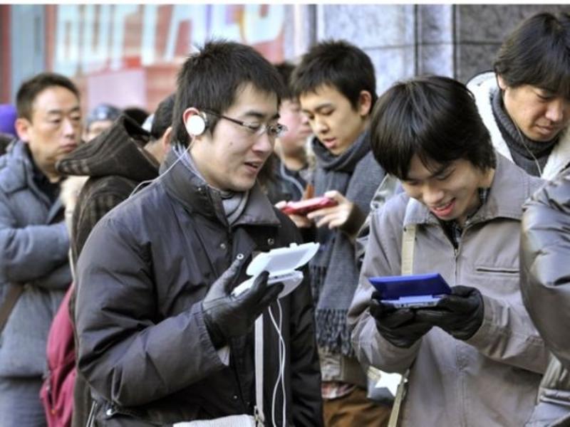 资料图：2011年2月26日，在日本东京一家电器商店外，年轻人排队购买任天堂掌上游戏机。（新华/法新）