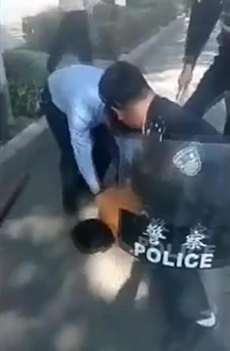 民警控制着嫌疑人。