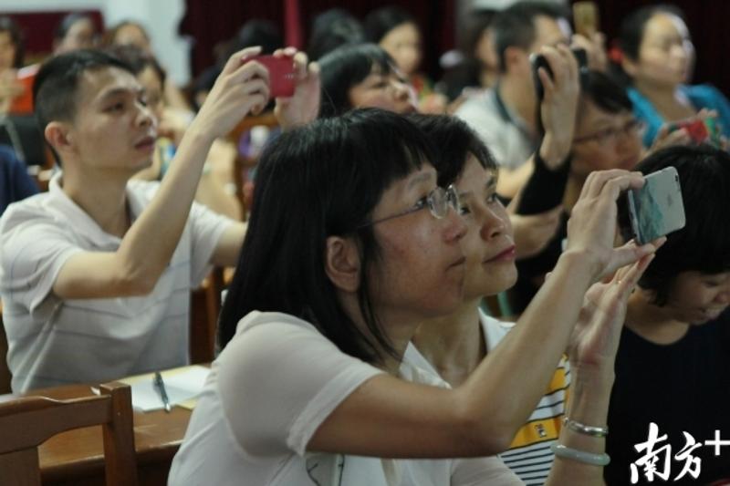 2016年越秀区小学升初中电脑派位,老师和家长代表用手机记录电脑派位经过。 南方日报记者 梁文祥 摄