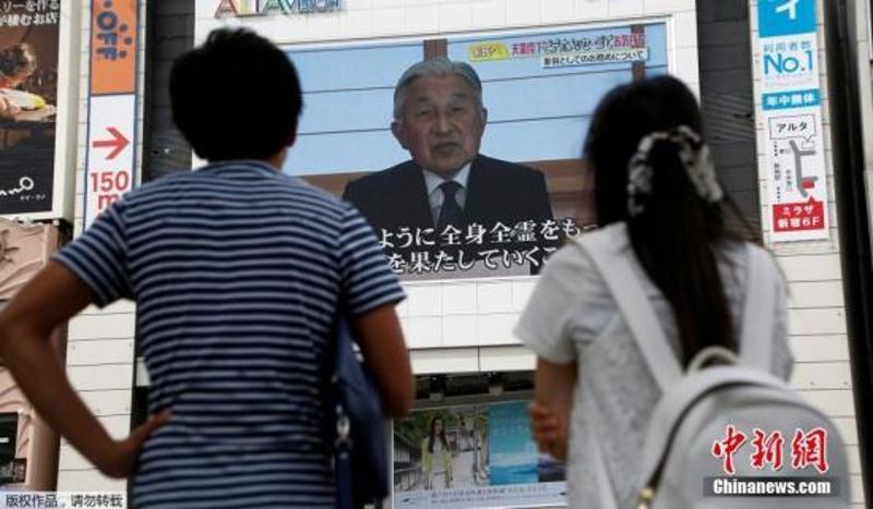 资料图：日本天皇当地时间8月8日下午3点通过视频表达了作为象征天皇关于公务的想法，显示出欲实现生前退位的强烈愿望。图为民众通过大屏幕观看天皇的视频讲话。