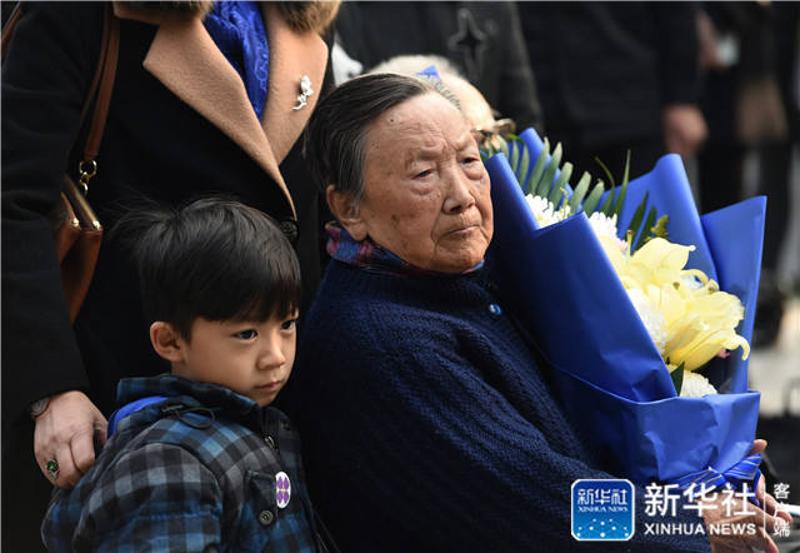 ↑12月3日，南京大屠杀幸存者夏淑琴（右）与家人一同祭奠南京大屠杀遇难者。 新华社记者 孙参 摄