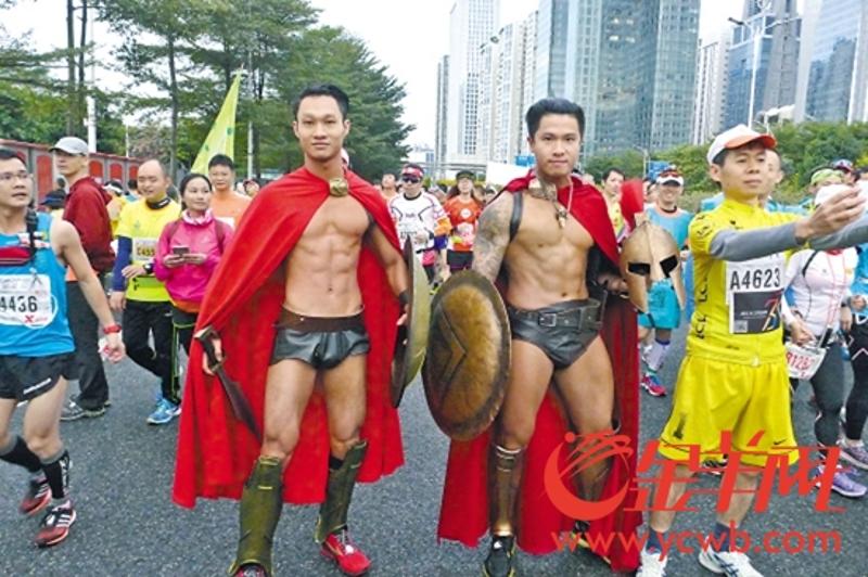 2015年12月6日羊城晚报头版用图，黎敬华（右）以斯巴达战士形象跑广马 林桂炎 摄