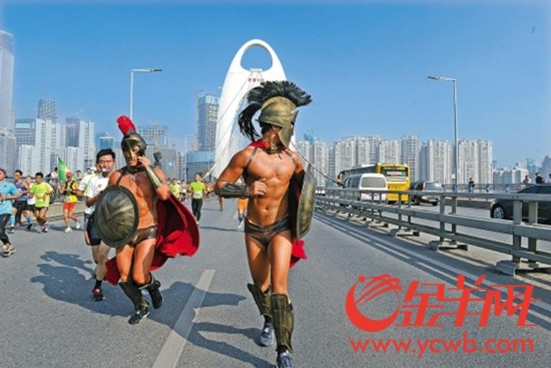 2014年11月23日羊城晚报头版用图，黎敬华（左）以斯巴达战士形象跑广马 林桂炎 摄