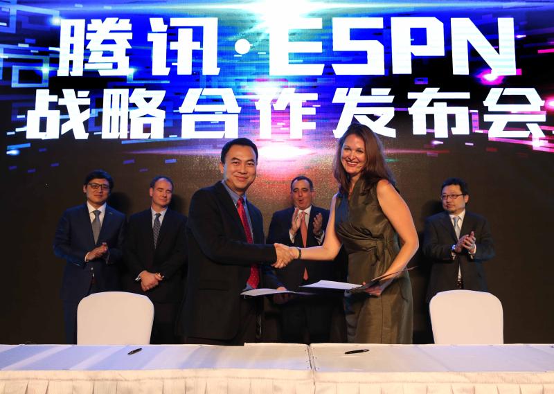 腾讯体育资讯部商务合作及市场总经理谢岳峰（左）与ESPN亚太区商务总监兼数字媒体主管凯莉·库克在签约后握手