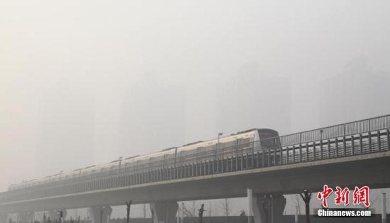 资料图：12月20日，一列地铁行驶在北京雾霾中。中新社记者 苏丹 摄