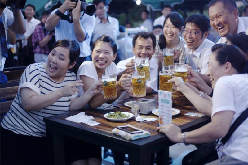 ↑ 8月12日，在朝鲜平壤，朝鲜市民在首届平壤大同江啤酒节上举杯狂欢。 新华社记者陆睿摄