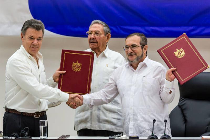 ↑ 6月23日，在古巴领导人劳尔·卡斯特罗（中）的见证下，哥伦比亚总统桑托斯（左）和“哥伦比亚革命武装力量”指挥官蒂莫莱翁·希门尼斯在古巴首都哈瓦那交换最终和平协议。 新华社记者刘彬摄
