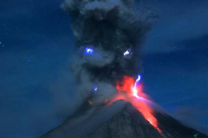 ↑ 2月29日，在印度尼西亚北苏门答腊省卡罗，锡纳朋火山在夜色中喷出的熔岩与火山灰好像一张喷射火焰的脸。 新华社发（金廷摄）