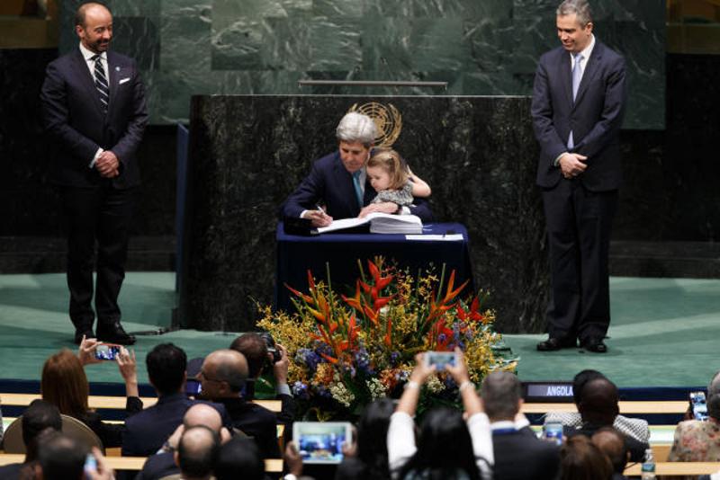 ↑4月22日，在纽约联合国总部，美国国务卿克里带着孙女在《巴黎协定》高级别签署仪式上签署这一协定。 新华社记者李木子摄