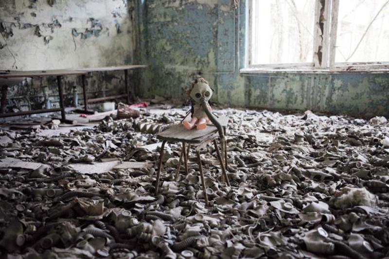 ↑ 4月19日，在乌克兰北部切尔诺贝利核电站附近的普里皮亚季市，一所废弃学校内的洋娃娃被戴上了防毒面具。 新华社记者戴天放摄