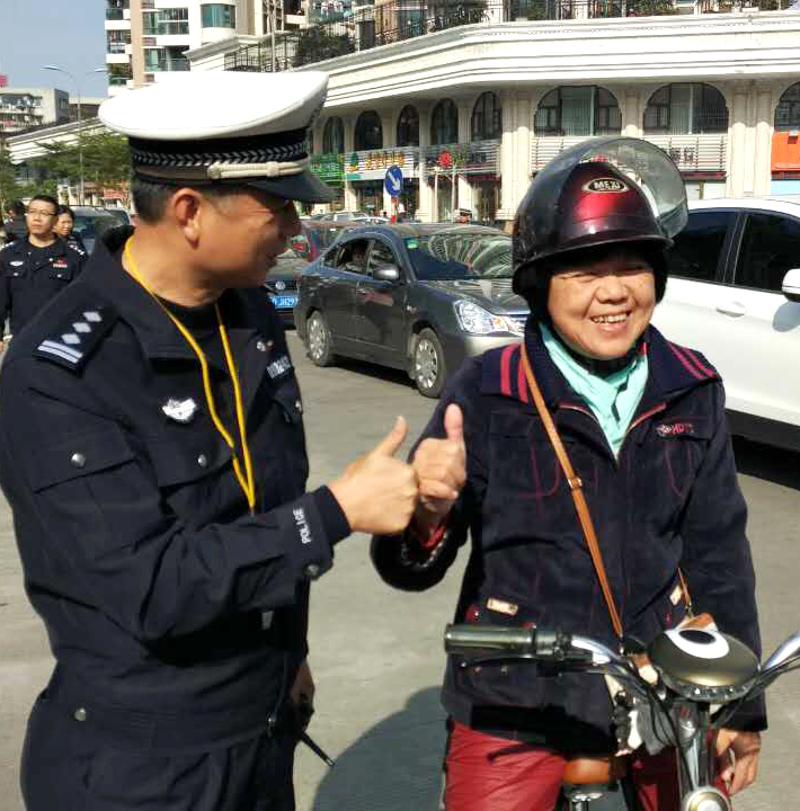 戴着头盔驾驶助力车的市民蔡女士正好经过执法行动现场，她主动对交警竖起大拇指。宋振威 摄