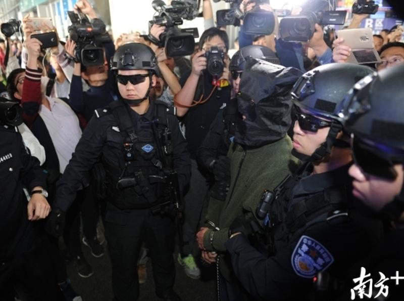 6日下午，嫌犯在警方的押送下回到广州。（南方日报记者 张梓望 摄）