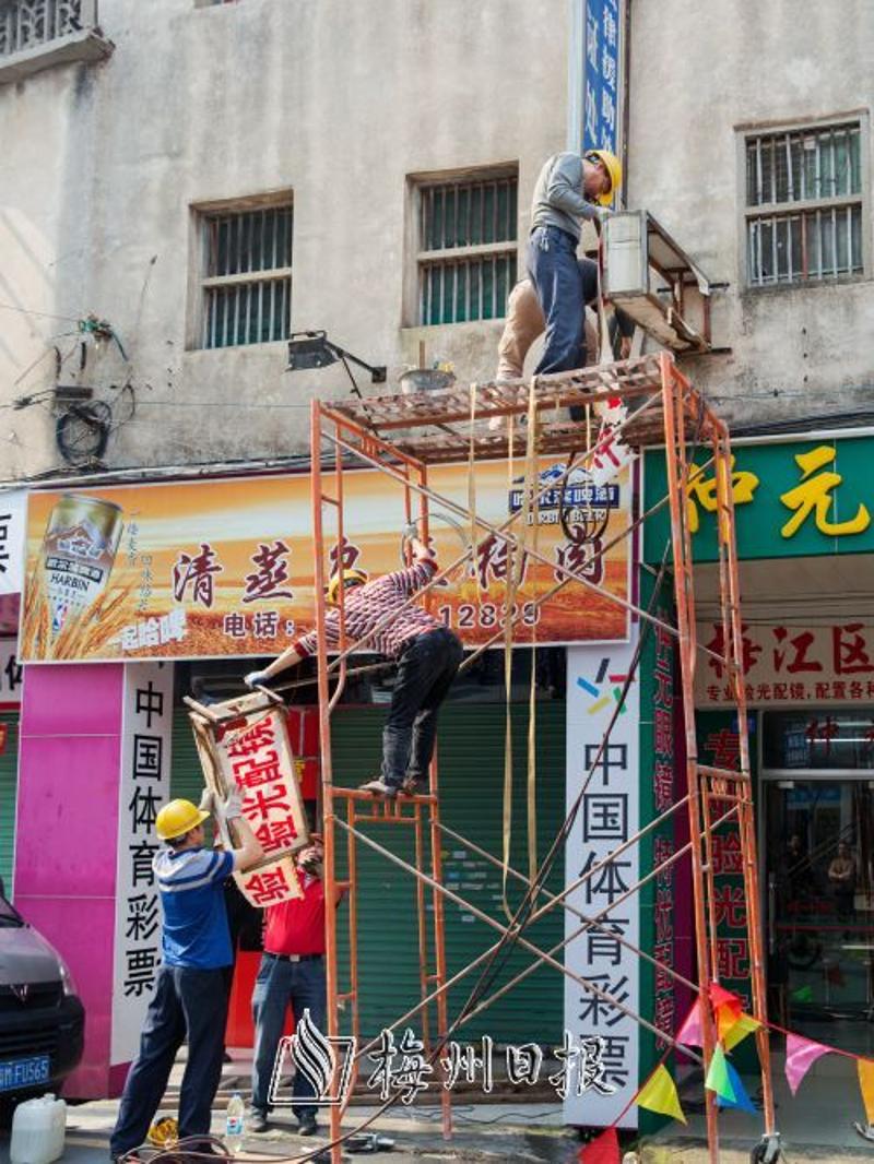 工作人员在拆除不规范广告牌。