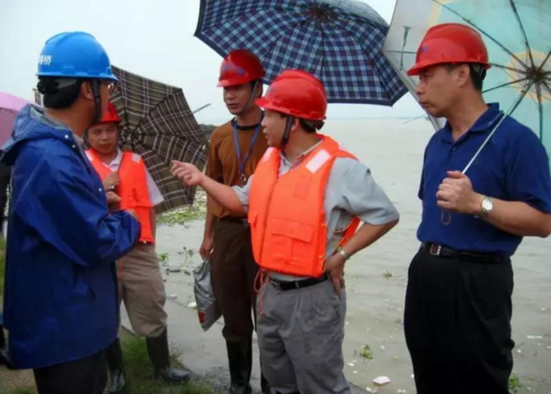 （▲出任市公路管理局局长期间，马文田还冒雨亲临洪灾现场指导抢险工作。）