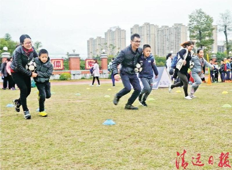 13日,新北江小学足球“嘉年华”活动中,学生们与家长互动玩足球“三文治”。（清远日报记者　黄昱茜　摄）