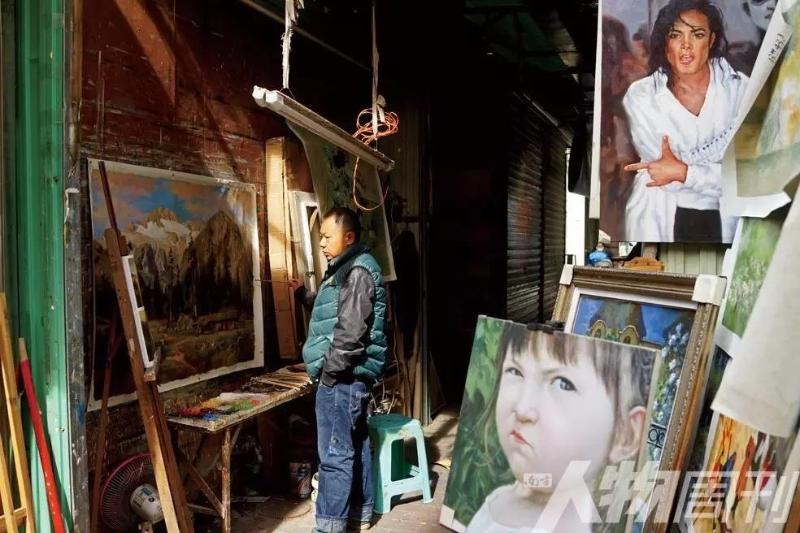 大芬村，一位画师在巷子口画画 图/本刊记者 大食