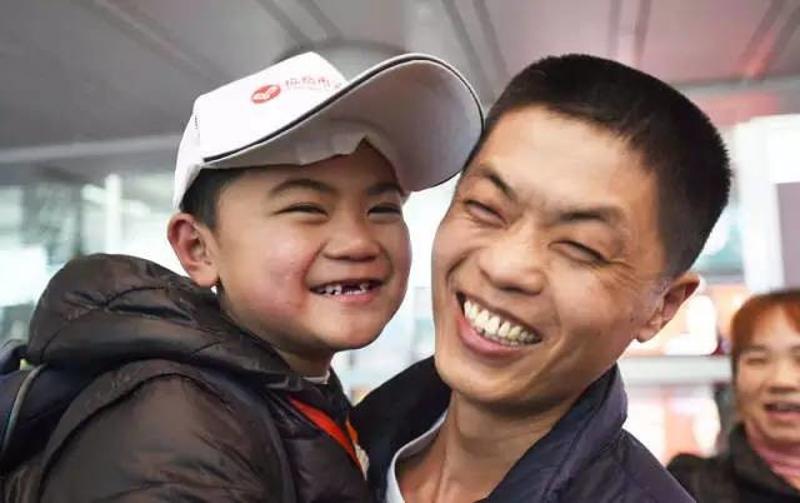 1月22日，在广州白云机场，留守儿童王文轩（左）见到爸爸王德俊后开心不已。新华社记者 薛玉斌 摄