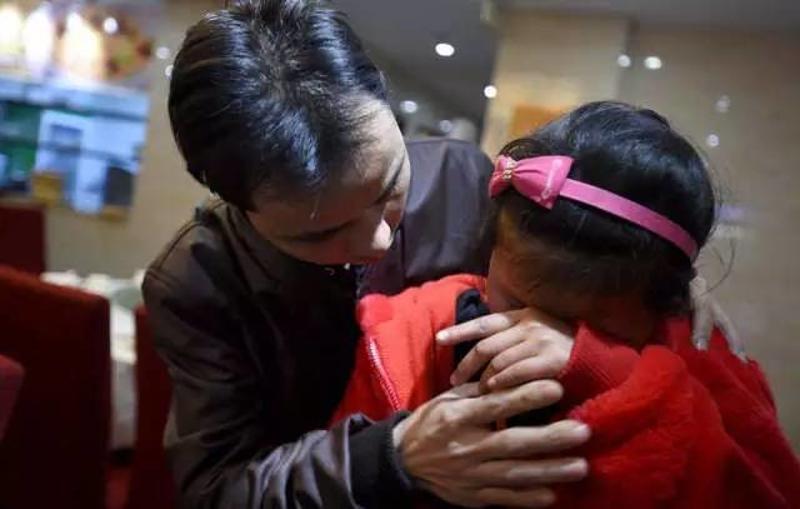 1月22日，在广州某饭店内的团聚现场，留守儿童陈莹莹（右）见到爸爸陈顺华后流泪。新华社记者 薛玉斌 摄