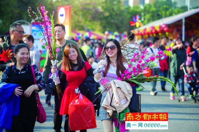 1月25日，天河迎春花市，手拿年花满脸欢容的市民。南都记者谭庆驹 摄 