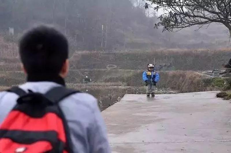 ▲在回家的路口，石欣突然发现3岁的儿子站在树下等着自己。