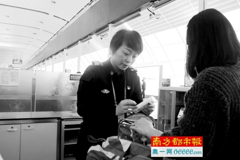 白云机场安检员邓力仔细检查旅客行李中的化妆品。