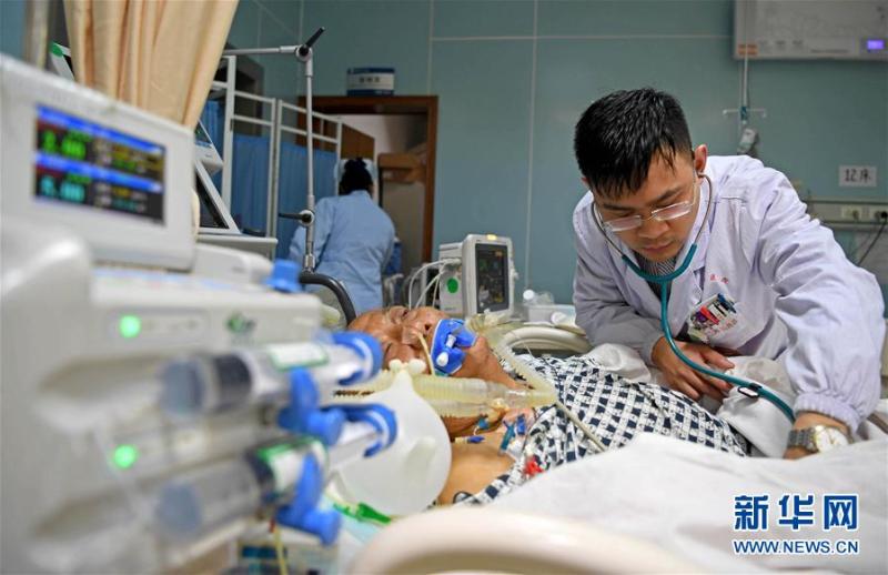 1月28日，南昌大学第二附属医院急诊科医生李金在重症监护室里为一名患者听诊。