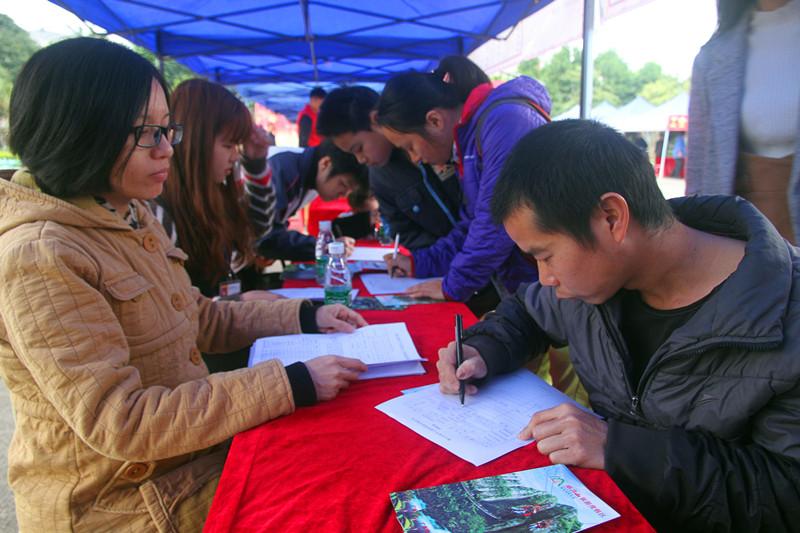 2月6日，三水区南山镇举办2017年新春人力资源招聘会，求职者在招聘摊位前填写求职信息。（林洛峰摄）