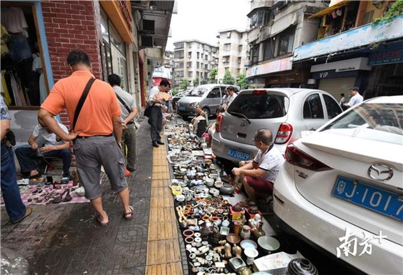 这一年多来，古玩地摊从商业城扩散到外面的大街上来。杨兴乐摄