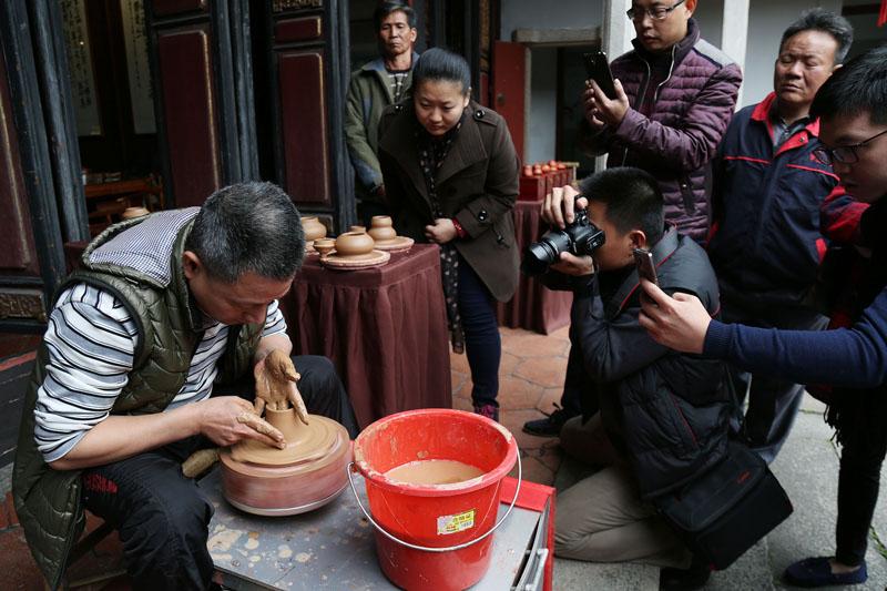 27日,泓德茶文化交流中心,潮州手拉壶大师吴敬亮为游客展示手拉壶制作