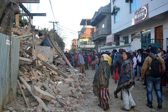 在印度因帕尔,人们查看一处在地震中受损的房屋新华社发